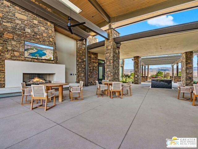 view of patio with a mountain view, an outdoor fireplace, and a pergola