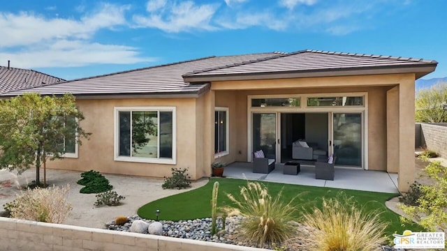 rear view of house with outdoor lounge area and a patio