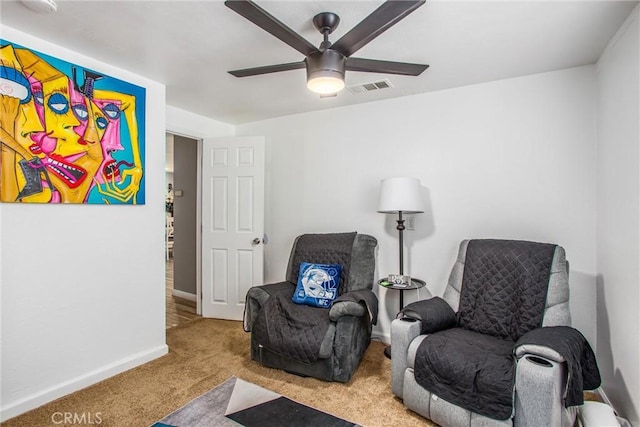 living area featuring ceiling fan and light colored carpet