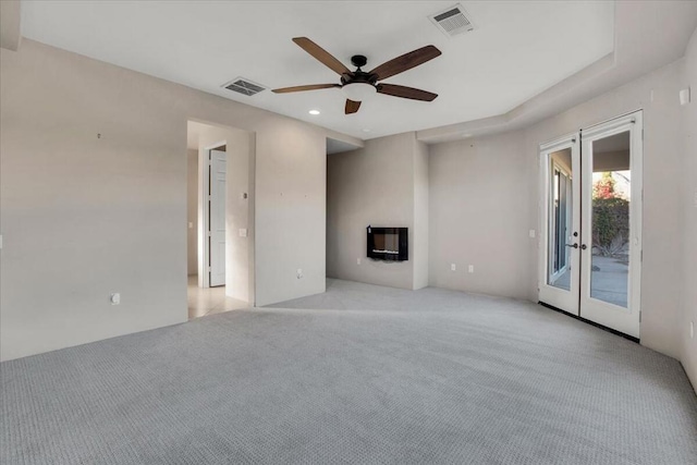 unfurnished living room featuring light carpet, ceiling fan, and french doors