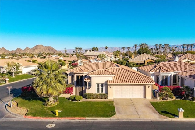 mediterranean / spanish-style house with a mountain view, a garage, and a front lawn