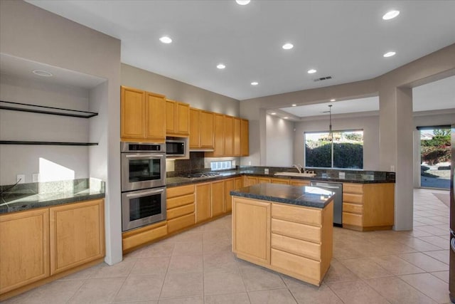 kitchen featuring appliances with stainless steel finishes, light brown cabinetry, a center island, and sink