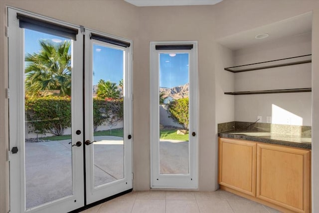 doorway with light tile patterned flooring