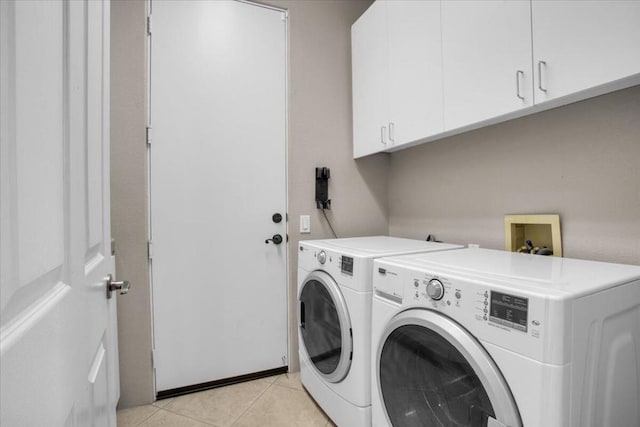 washroom with cabinets, separate washer and dryer, and light tile patterned floors