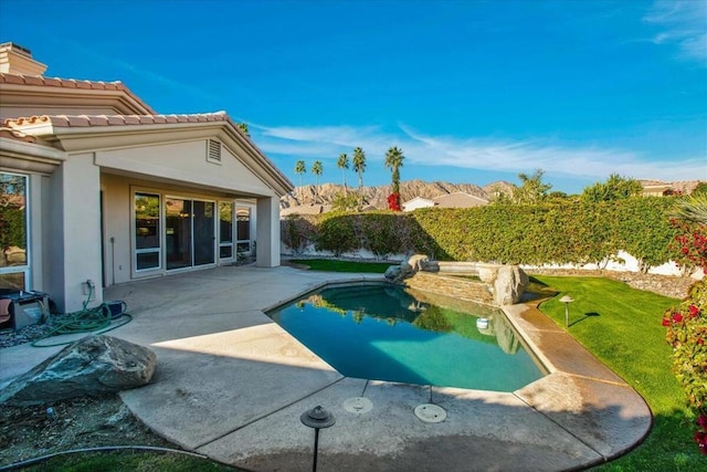 view of pool with a lawn and a patio area