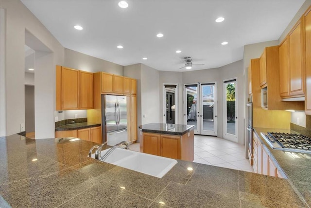 kitchen with sink, light brown cabinets, appliances with stainless steel finishes, kitchen peninsula, and a kitchen island