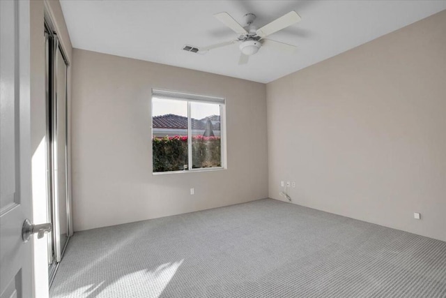 carpeted spare room featuring ceiling fan