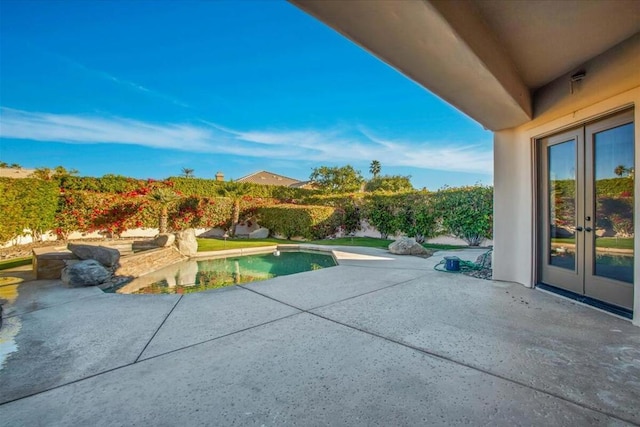 view of swimming pool with a patio and french doors