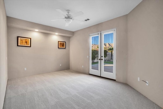 carpeted spare room with french doors and ceiling fan