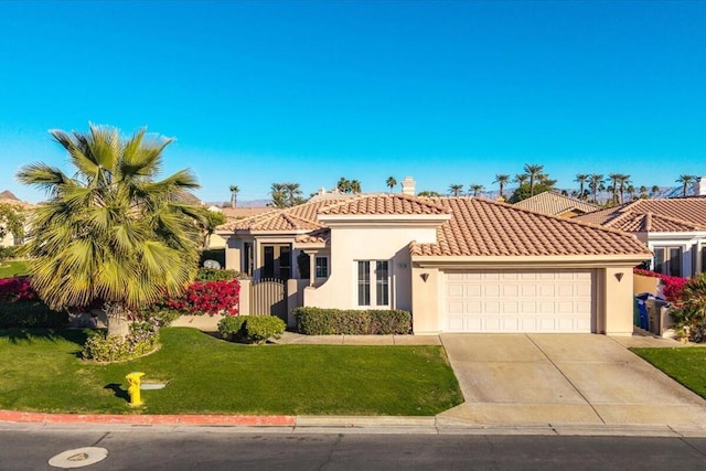 mediterranean / spanish house featuring a garage and a front yard