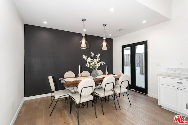 dining room with light hardwood / wood-style floors and french doors