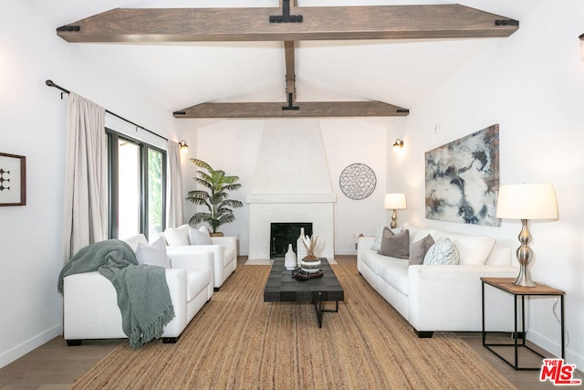 living room featuring a large fireplace, lofted ceiling with beams, and hardwood / wood-style floors