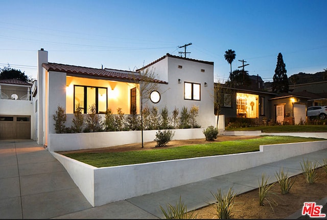 mediterranean / spanish house featuring a garage and a front yard