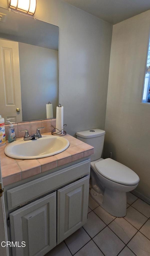 bathroom featuring toilet, tile patterned flooring, and vanity