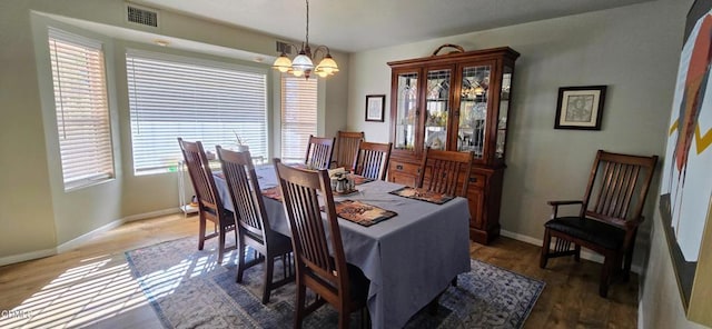 dining area with a notable chandelier and dark hardwood / wood-style floors