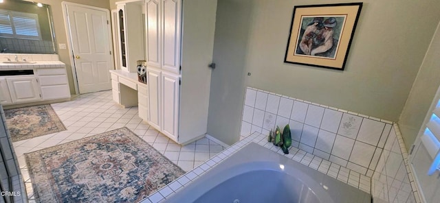 bathroom with a tub to relax in, vanity, and tile patterned flooring