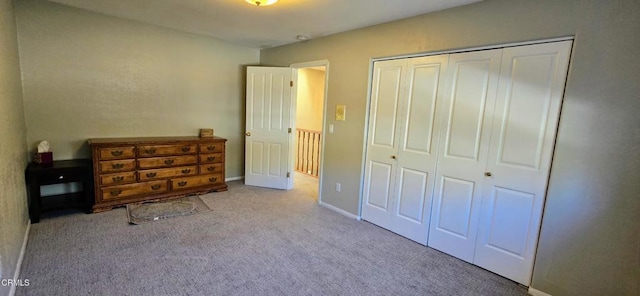 unfurnished bedroom with a closet and light colored carpet