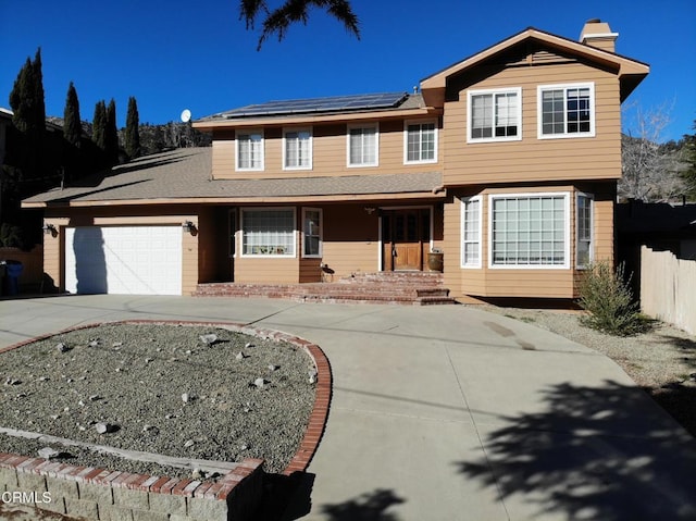 view of front of home featuring a garage and solar panels