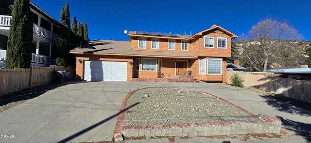 view of property featuring a garage and solar panels