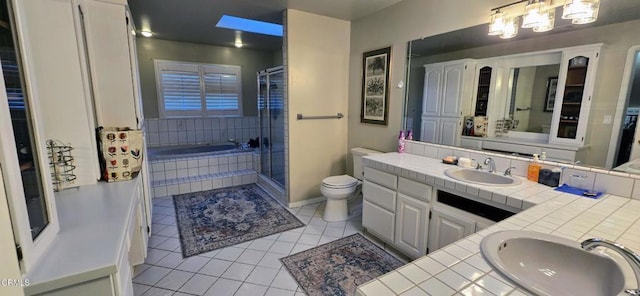 bathroom featuring toilet, vanity, tile patterned flooring, and a relaxing tiled tub