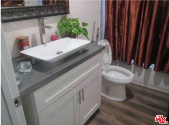 bathroom featuring vanity, wood-type flooring, and toilet