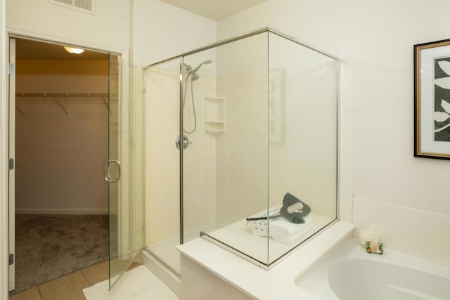 bathroom featuring tile patterned flooring and shower with separate bathtub