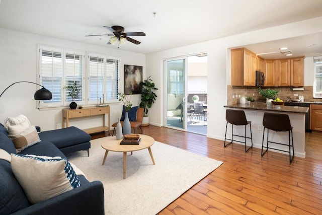 living room with ceiling fan and light hardwood / wood-style flooring