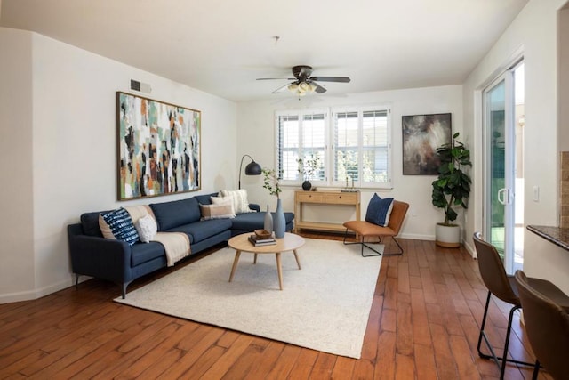 living room featuring ceiling fan and dark hardwood / wood-style floors