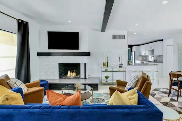 living room with sink, a high end fireplace, and beam ceiling