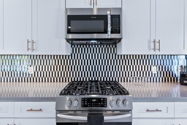 kitchen featuring white cabinets, decorative backsplash, and appliances with stainless steel finishes