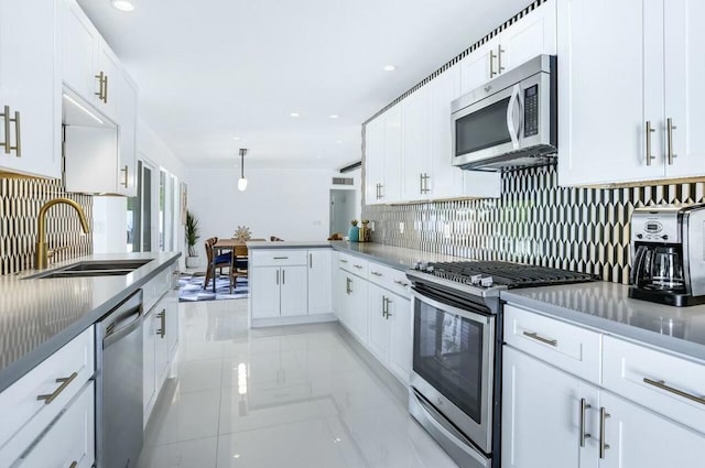 kitchen with decorative backsplash, appliances with stainless steel finishes, sink, and white cabinetry