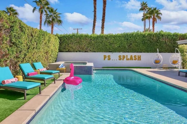 view of swimming pool featuring a patio area and an in ground hot tub