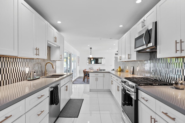 kitchen featuring stainless steel appliances, decorative backsplash, decorative light fixtures, white cabinets, and sink