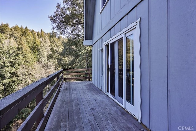 wooden terrace featuring a forest view