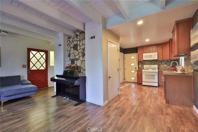 kitchen featuring a sink, visible vents, light wood finished floors, and white appliances