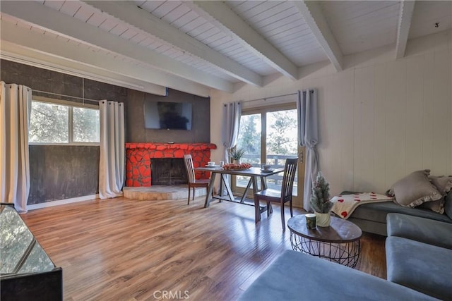living room featuring a healthy amount of sunlight, beamed ceiling, and wood finished floors