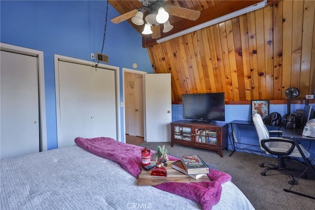 bedroom featuring visible vents, high vaulted ceiling, carpet flooring, and two closets