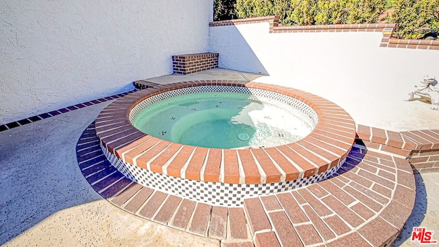 view of swimming pool featuring an in ground hot tub