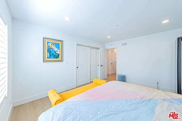 bedroom with a closet and light hardwood / wood-style flooring