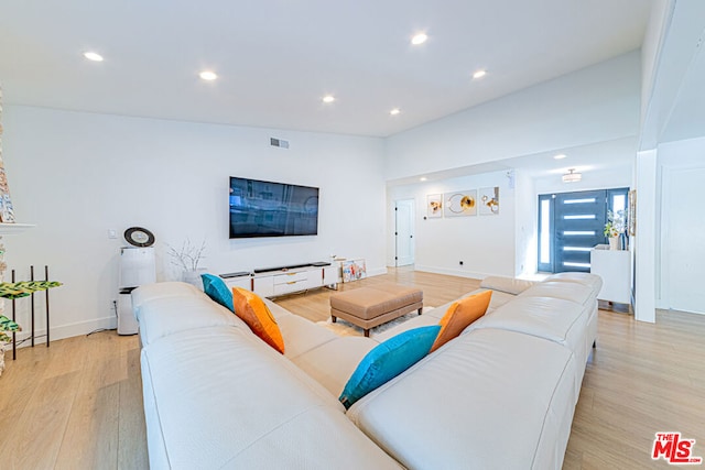 living room featuring vaulted ceiling and light hardwood / wood-style flooring