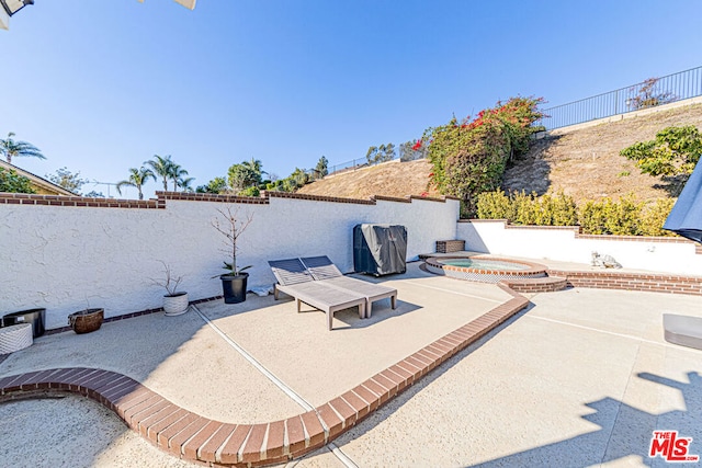 view of patio / terrace featuring an in ground hot tub