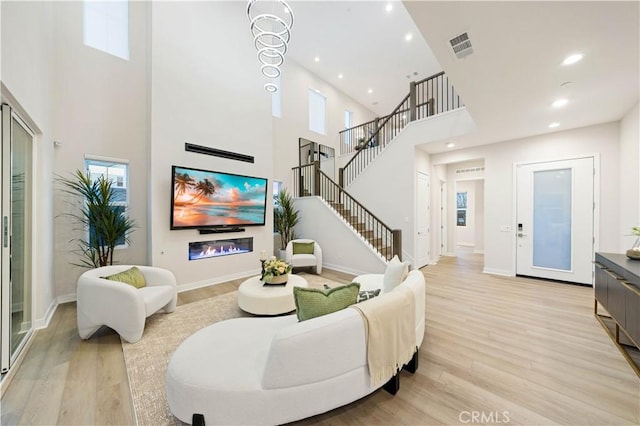 living room with a high ceiling and light hardwood / wood-style flooring