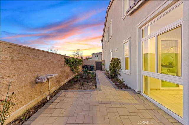 property exterior at dusk with a patio area