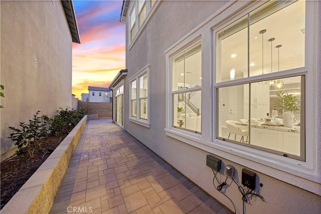 property exterior at dusk featuring a patio area