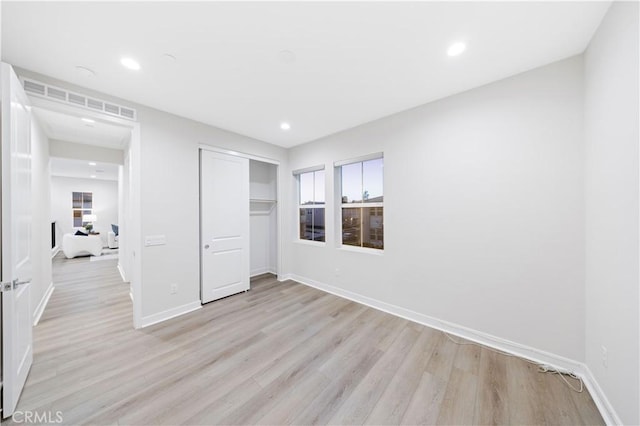 unfurnished bedroom with light hardwood / wood-style floors and a closet