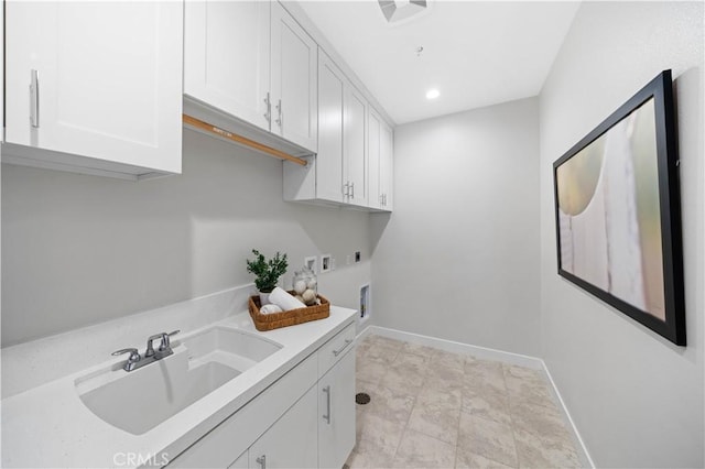 clothes washing area featuring washer hookup, sink, electric dryer hookup, and cabinets