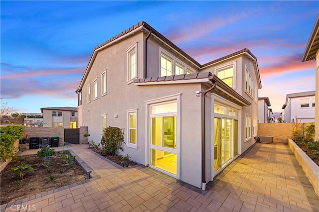 property exterior at dusk with a patio area