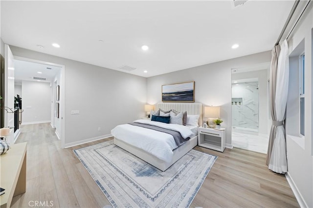 bedroom featuring light hardwood / wood-style floors and connected bathroom