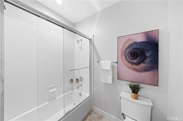 bathroom with toilet and bath / shower combo with glass door