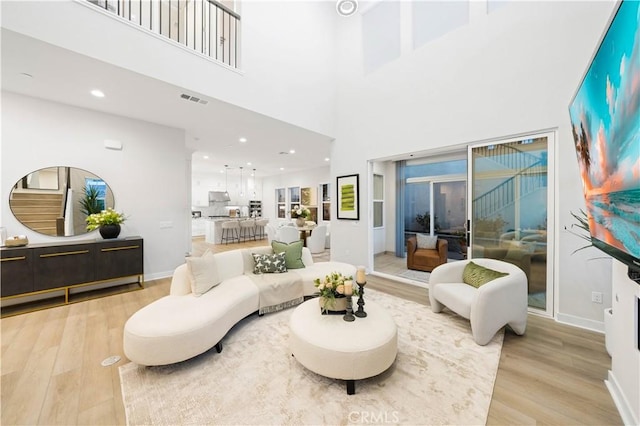 living room featuring light hardwood / wood-style floors and a high ceiling